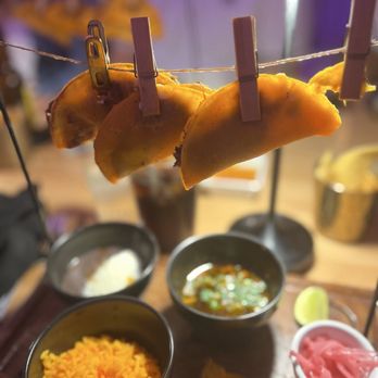 Tacos del Cartel signature dishes Birria TacosCarne Asada TacosElote (Street Corn)Churro Bites